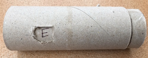 An assembled cryptex made from toilet tubes showing a letter revealed